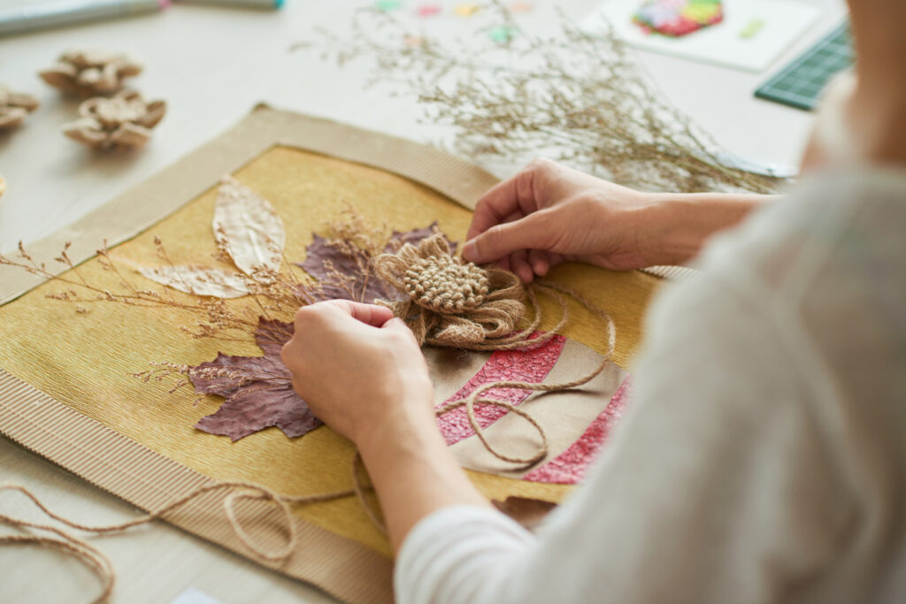 Amazon Handmade artisan beginners - Hands crafting a decorative piece with natural and dried materials.