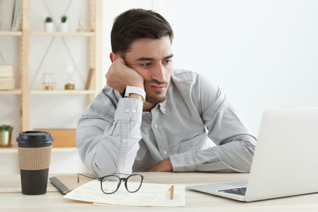 Walmart seller challenges - A male online seller looks frustrated while working on a laptop