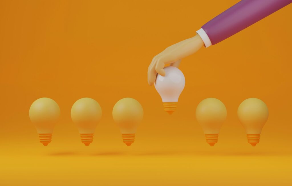 Amazon seller insights - A hand placing a glowing light bulb, representing a great idea