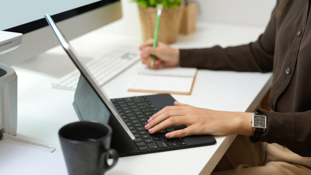Amazon FBA courses - A person working at a desk on a laptop and taking notes