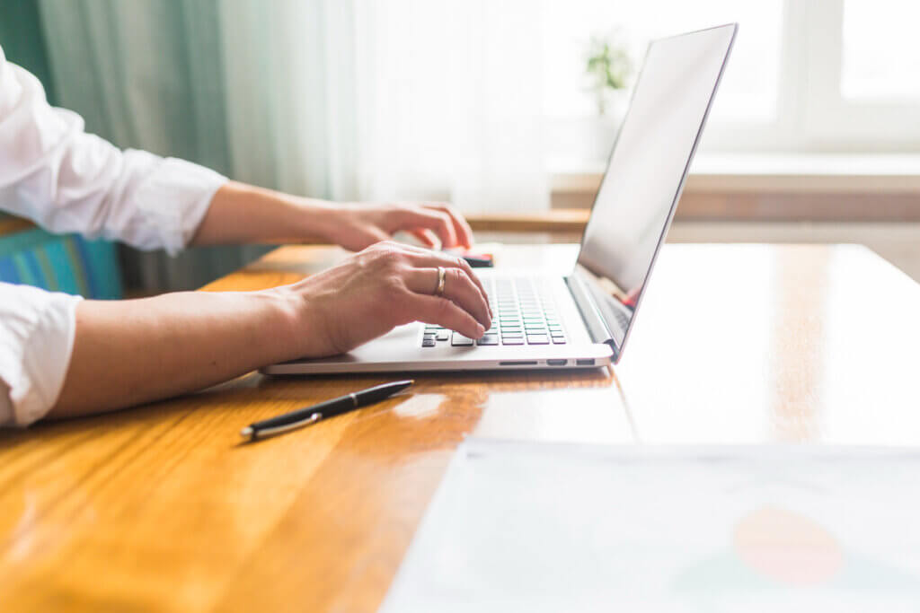 Amazon product research guide - A person typing on a laptop, conducting market research
