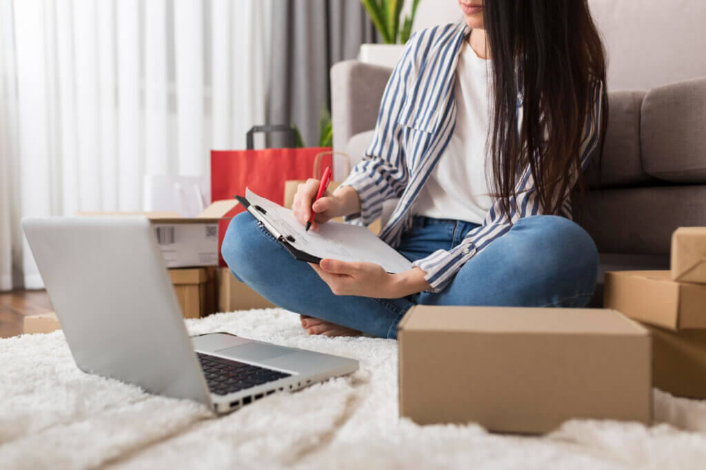 Amazon business models for sellers - A woman sitting on the floor surrounded by shipping boxes
