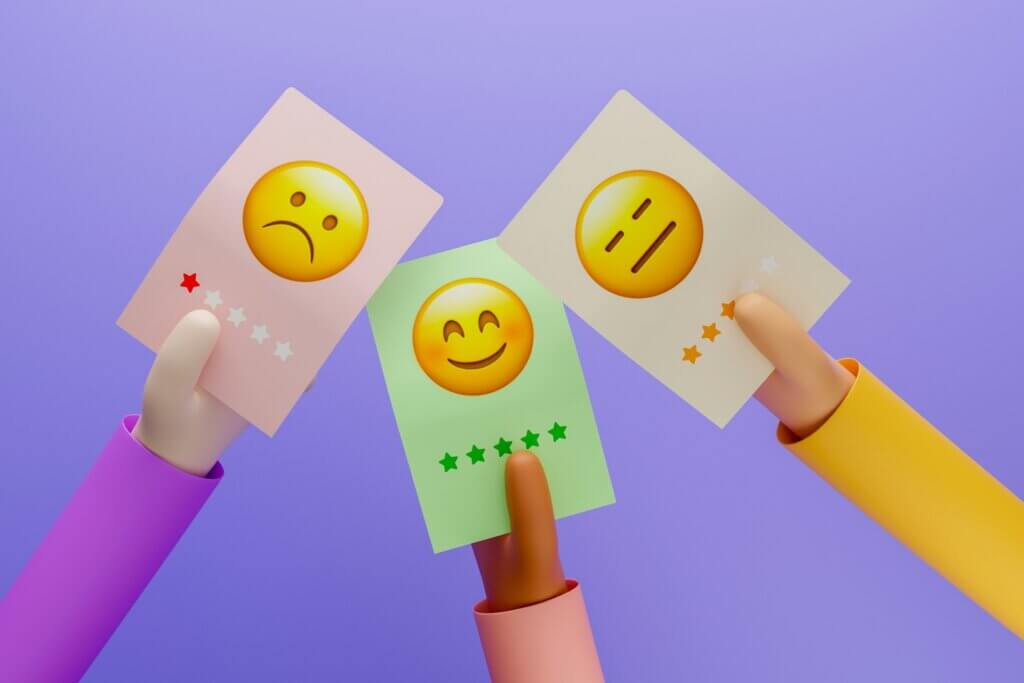 Fake Amazon reviews - Three hands holding cards showing different customer reviews ranging from negative to positive