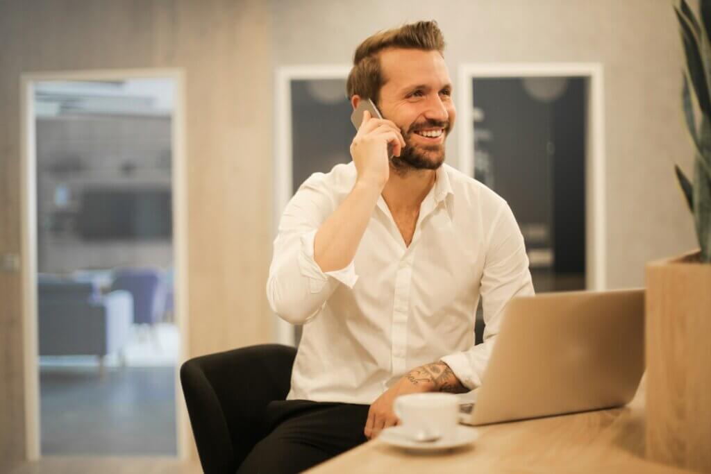 Man using phone to call Amazon seller central support smiling